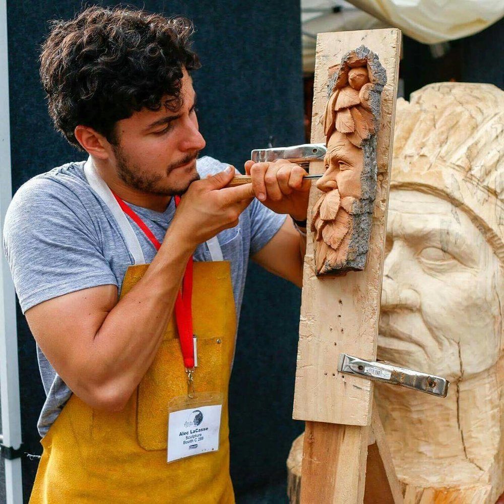 Alec LaCasse carving a face in bark